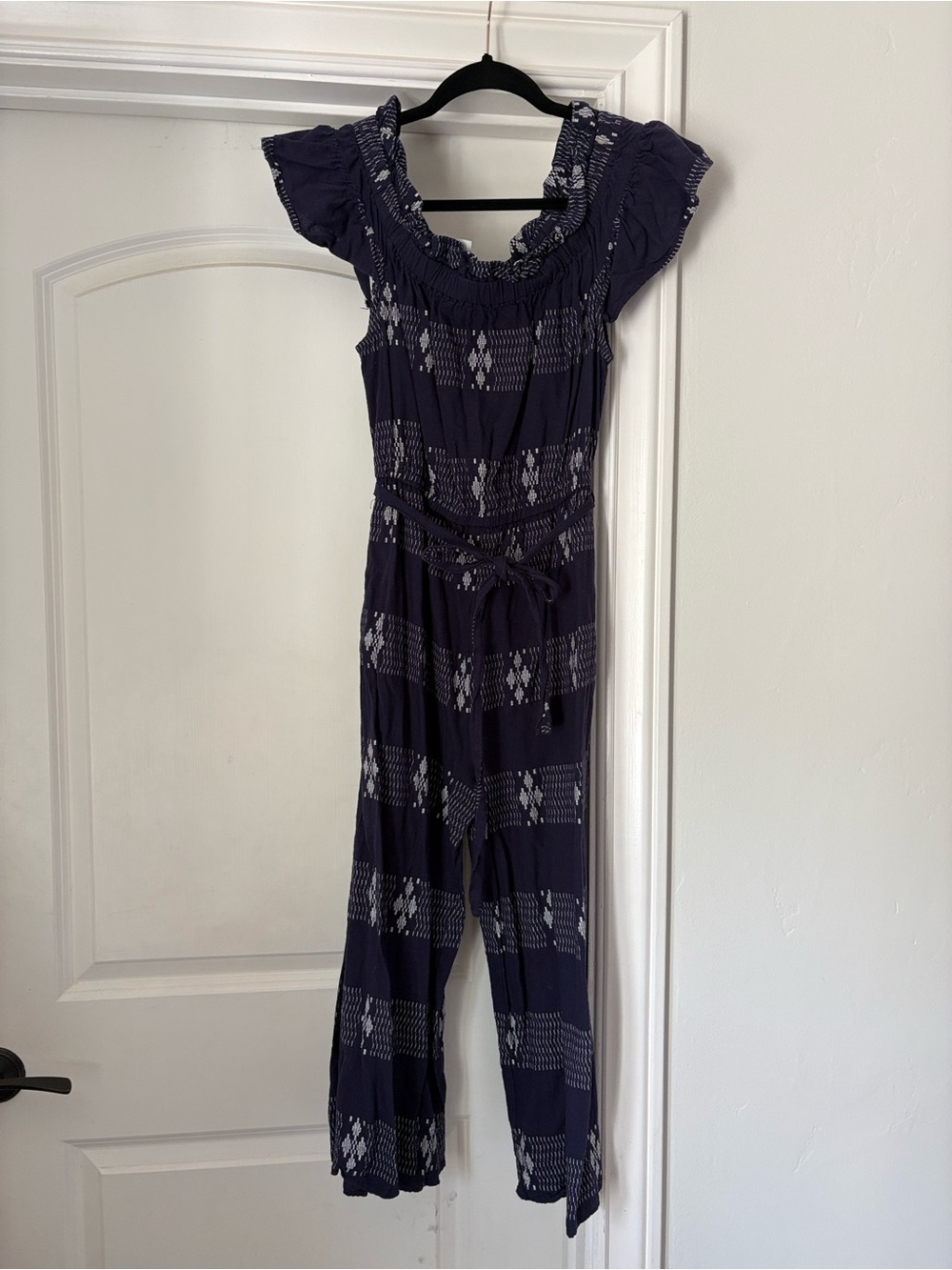 Corey Lynn Calter at Anthropologie Navy Patterned Smocked Off-Shoulder Jumpsuit
